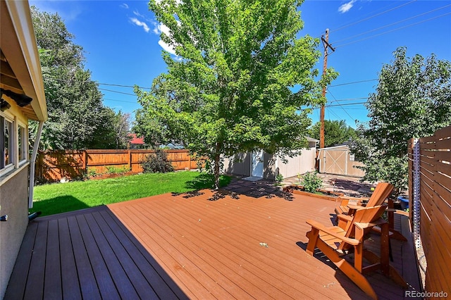 wooden deck featuring a lawn and a storage shed