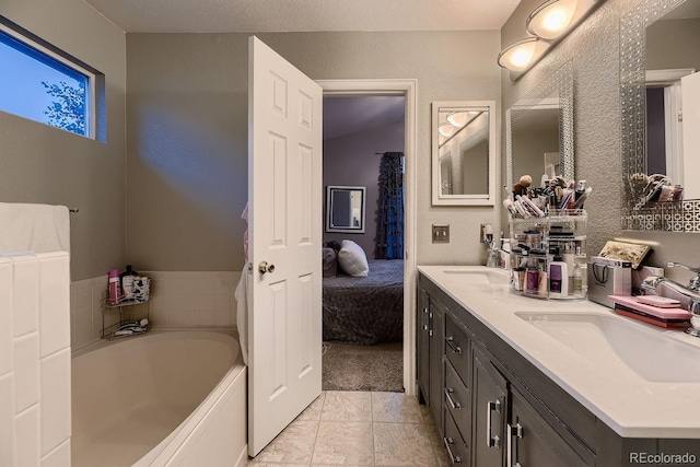 bathroom with a textured ceiling, a bathtub, vanity, and lofted ceiling