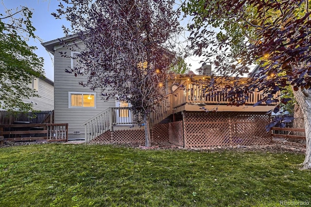 back of house featuring a lawn and a deck