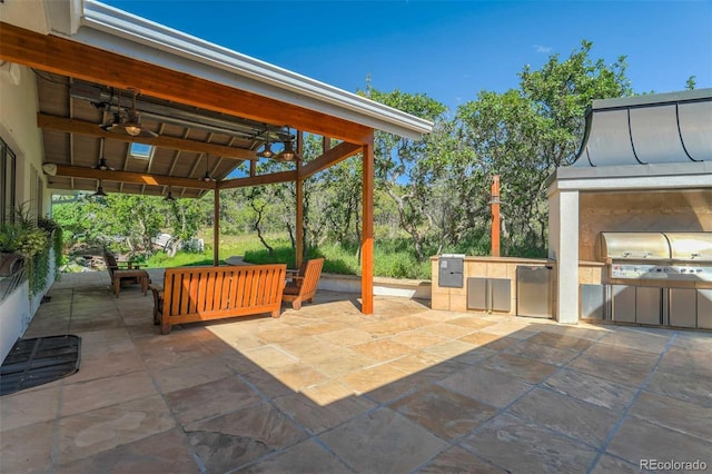 view of patio with an outdoor kitchen, ceiling fan, and a grill