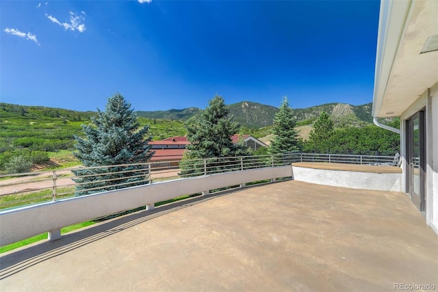 view of patio with a mountain view and a balcony