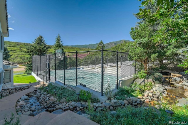 view of sport court featuring a mountain view and basketball court