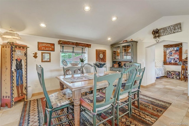 tiled dining area featuring vaulted ceiling