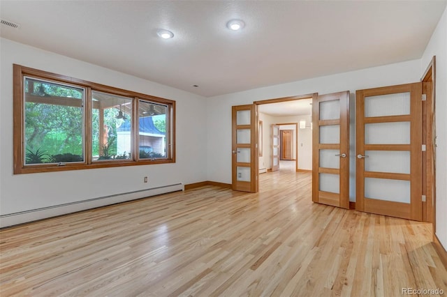 unfurnished room with french doors, light hardwood / wood-style flooring, and baseboard heating