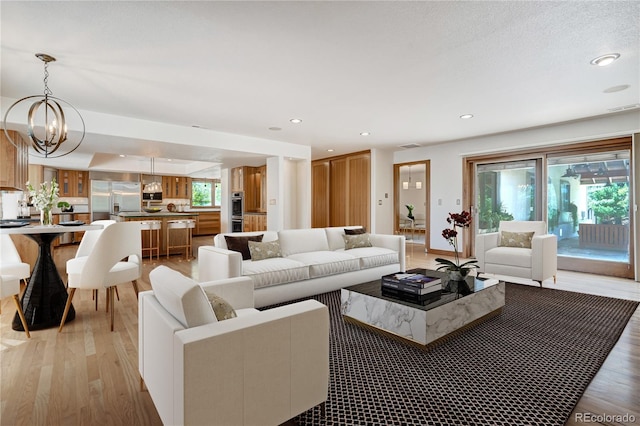 living room with light hardwood / wood-style floors and a chandelier