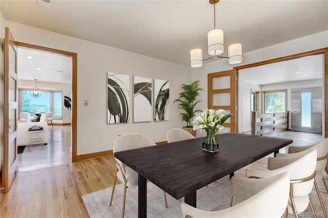 dining area featuring a chandelier, light hardwood / wood-style flooring, and a healthy amount of sunlight