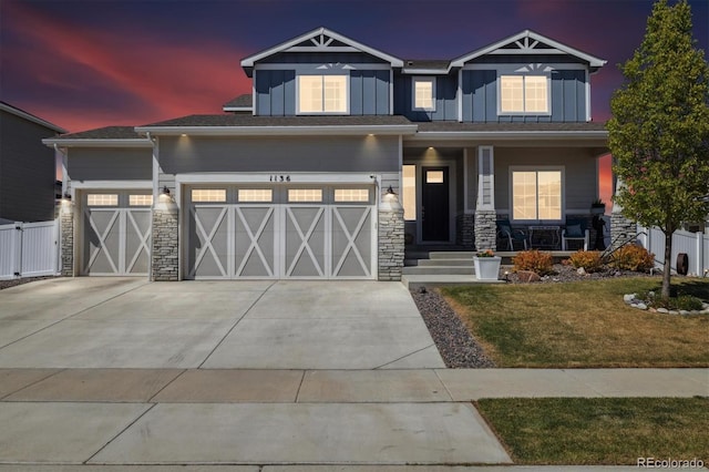 craftsman house featuring board and batten siding, covered porch, and stone siding