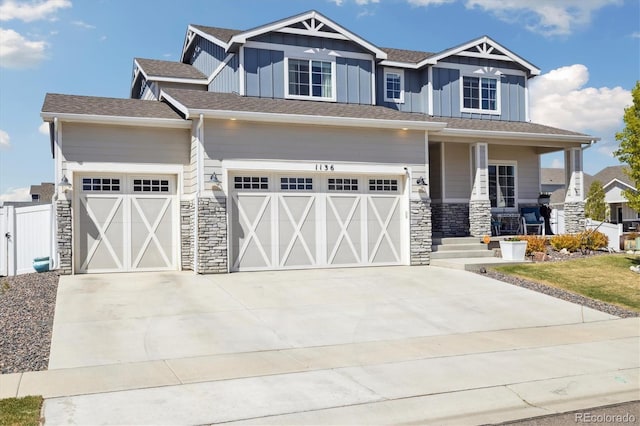 craftsman-style house featuring stone siding, a porch, board and batten siding, and driveway