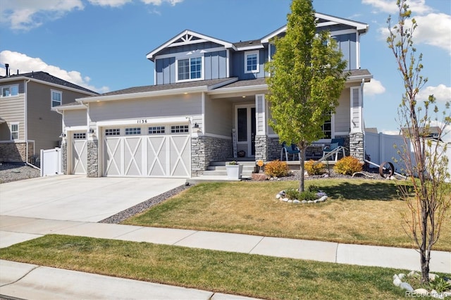 craftsman-style house featuring covered porch, board and batten siding, fence, and stone siding