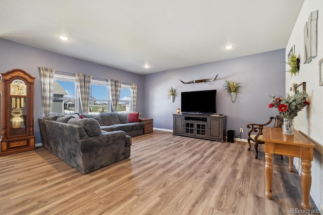living room featuring baseboards, light wood-style floors, and recessed lighting
