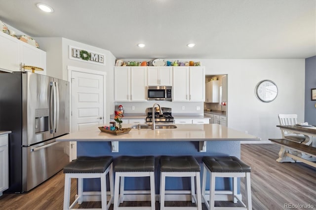 kitchen featuring a kitchen breakfast bar, white cabinetry, and appliances with stainless steel finishes