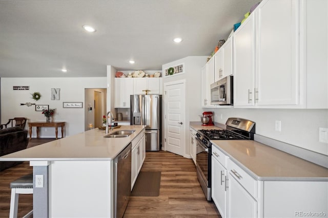 kitchen featuring a breakfast bar area, recessed lighting, a sink, wood finished floors, and stainless steel appliances