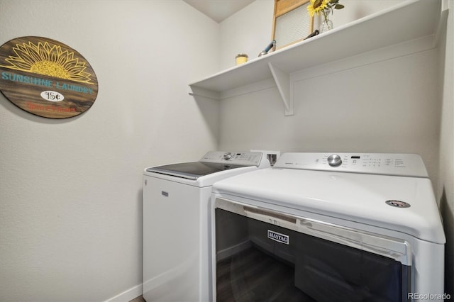 laundry area featuring dark wood finished floors, laundry area, independent washer and dryer, and baseboards