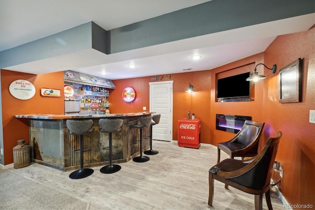 bar featuring wood finished floors, visible vents, baseboards, a dry bar, and recessed lighting