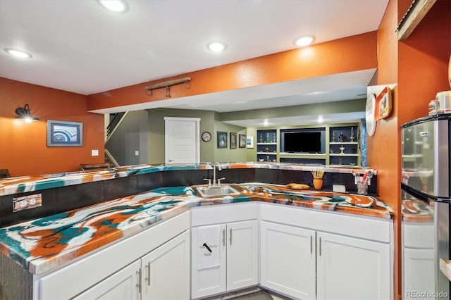 kitchen featuring open floor plan, recessed lighting, a sink, and white cabinets