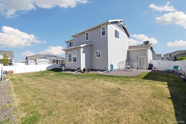 rear view of property with a fenced backyard, board and batten siding, a yard, and a residential view