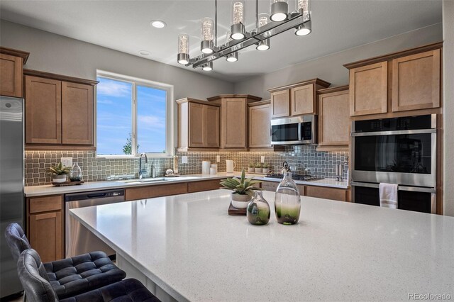 9389 Mayflower Gulch Way, Colorado Springs, CO 80927 - kitchen featuring stainless steel appliances, a sink, light countertops, and tasteful backsplash