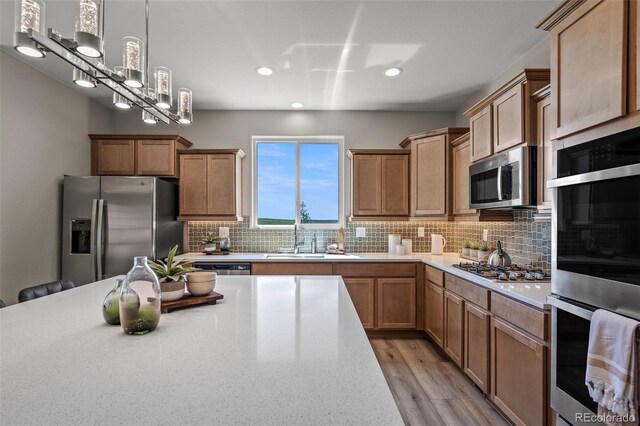 9389 Mayflower Gulch Way, Colorado Springs, CO 80927 - kitchen featuring appliances with stainless steel finishes, a sink, recessed lighting, decorative backsplash, and light wood-style floors