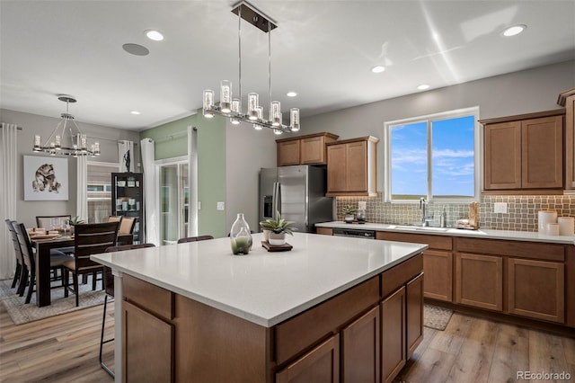 9389 Mayflower Gulch Way, Colorado Springs, CO 80927 - kitchen with appliances with stainless steel finishes, a chandelier, backsplash, light wood-style flooring, and recessed lighting
