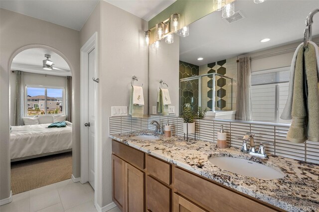 9389 Mayflower Gulch Way, Colorado Springs, CO 80927 - ensuite bathroom with a shower stall, double vanity, a ceiling fan, baseboards, and tile patterned flooring