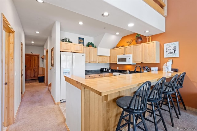 33 Broken Lance Dr Unit 207S, Breckenridge, CO 80424 - kitchen with white appliances, light brown cabinets, a peninsula, light carpet, and a breakfast bar area