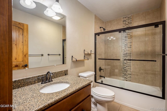 full bathroom featuring shower / bath combination with glass door, tile patterned flooring, vanity, and toilet