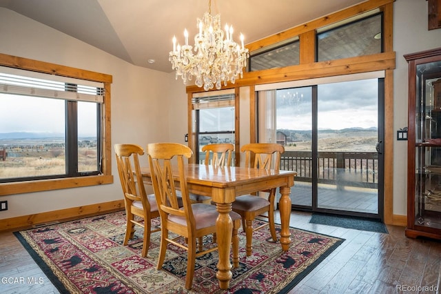 dining room featuring a mountain view, wood-type flooring, lofted ceiling, and an inviting chandelier