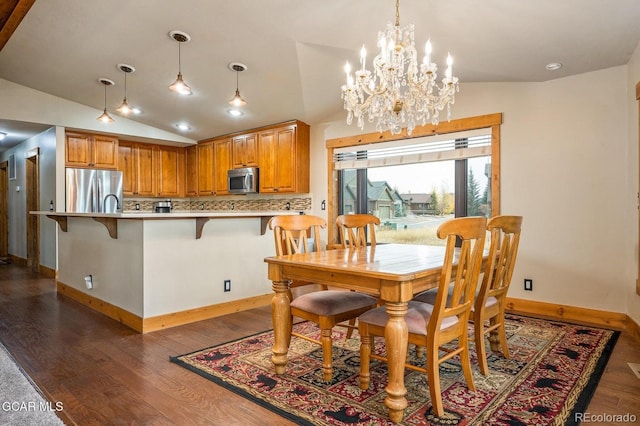 dining room with dark wood-type flooring, vaulted ceiling, and an inviting chandelier