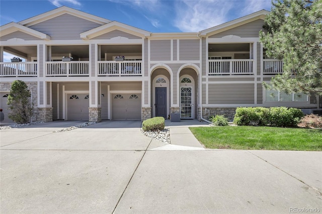 4251 S Blackhawk Cir Unit 3E, Aurora, CO 80014 - view of front of home featuring an attached garage, driveway, a balcony, and stone siding