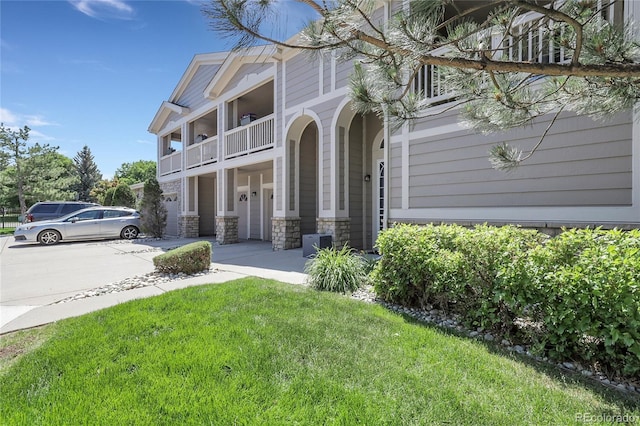 4251 S Blackhawk Cir Unit 3E, Aurora, CO 80014 - view of front of house featuring a balcony, stone siding, and a front lawn