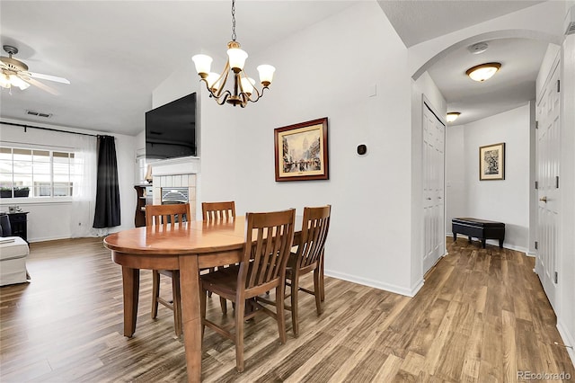 4251 S Blackhawk Cir Unit 3E, Aurora, CO 80014 - dining space with arched walkways, wood finished floors, a chandelier, and a ceiling fan