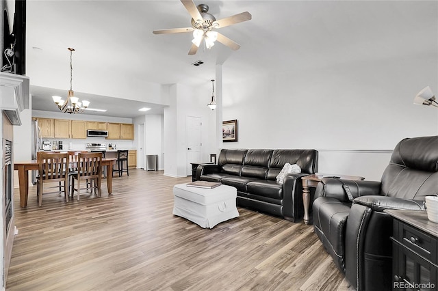 4251 S Blackhawk Cir Unit 3E, Aurora, CO 80014 - living area with a chandelier, ceiling fan, light wood finished floors, and a high ceiling