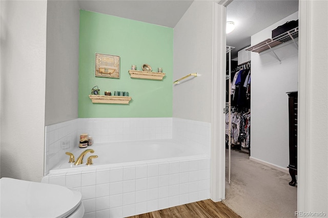 4251 S Blackhawk Cir Unit 3E, Aurora, CO 80014 - full bathroom featuring a bath, a spacious closet, and wood finished floors