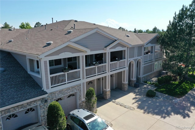 4251 S Blackhawk Cir Unit 3E, Aurora, CO 80014 - back of house with stone siding, a shingled roof, an attached garage, and a balcony