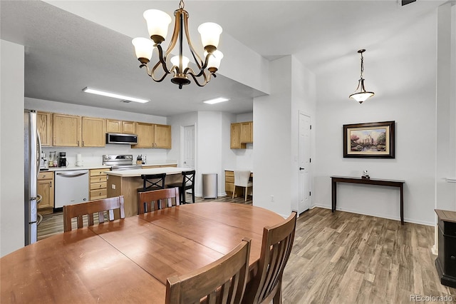 4251 S Blackhawk Cir Unit 3E, Aurora, CO 80014 - dining area featuring a chandelier and light wood-style flooring