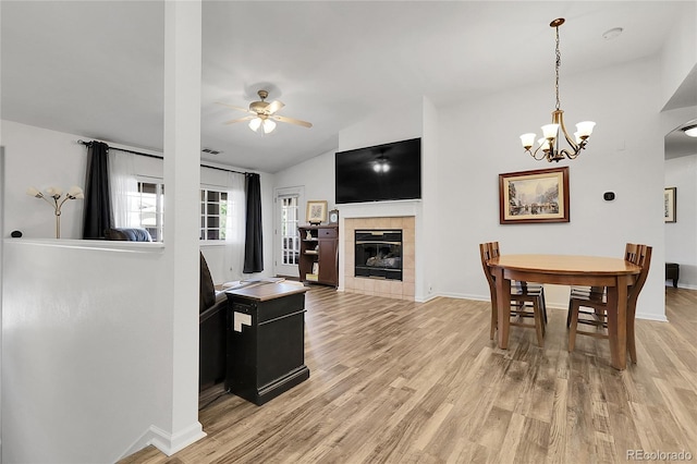 4251 S Blackhawk Cir Unit 3E, Aurora, CO 80014 - dining room featuring light wood-type flooring, a ceiling fan, lofted ceiling, a chandelier, and a tile fireplace