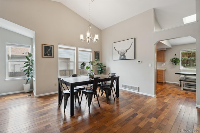7035 S Flower Ct, Littleton, CO 80128 - dining space with high vaulted ceiling, a chandelier, dark wood-style floors, arched walkways, and baseboards
