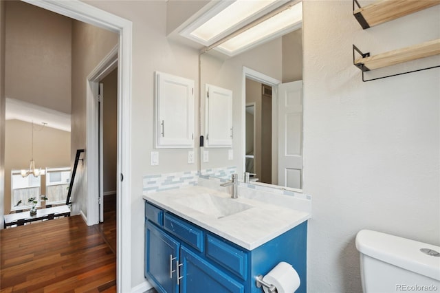 7035 S Flower Ct, Littleton, CO 80128 - half bathroom with vanity, toilet, a chandelier, and wood finished floors