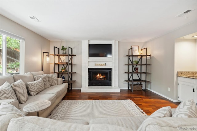 7035 S Flower Ct, Littleton, CO 80128 - living area featuring wood finished floors, a large fireplace, and baseboards