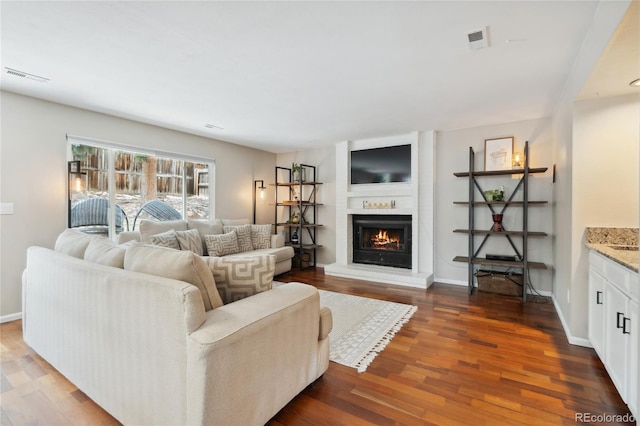 7035 S Flower Ct, Littleton, CO 80128 - living room with dark wood-type flooring, a large fireplace, and baseboards