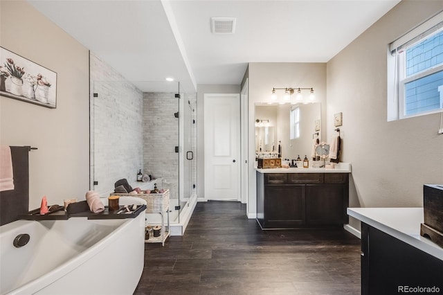 full bathroom featuring a freestanding tub, wood finished floors, vanity, visible vents, and a stall shower