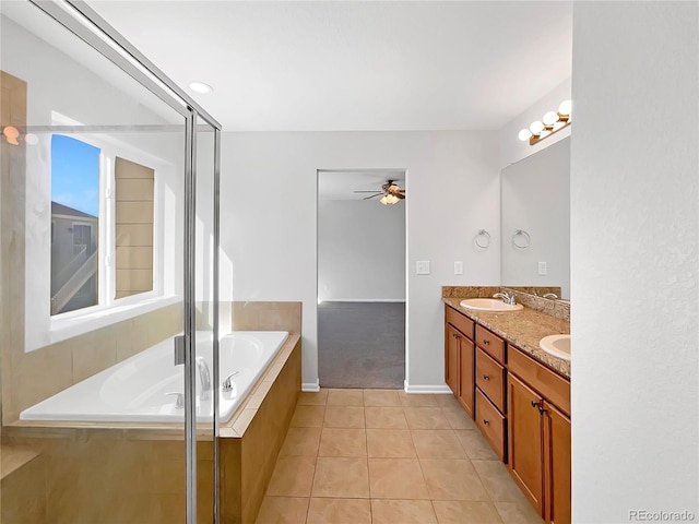 bathroom featuring a relaxing tiled tub, vanity, tile patterned floors, and ceiling fan