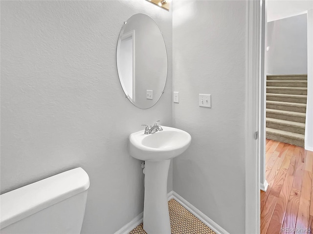 bathroom featuring wood-type flooring and toilet