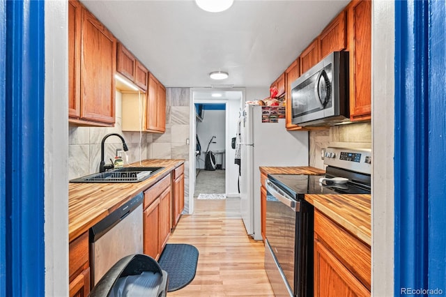 9700 E Iliff Ave Unit E51, Denver, CO 80231 - kitchen with appliances with stainless steel finishes, wood counters, light wood-type flooring, and backsplash