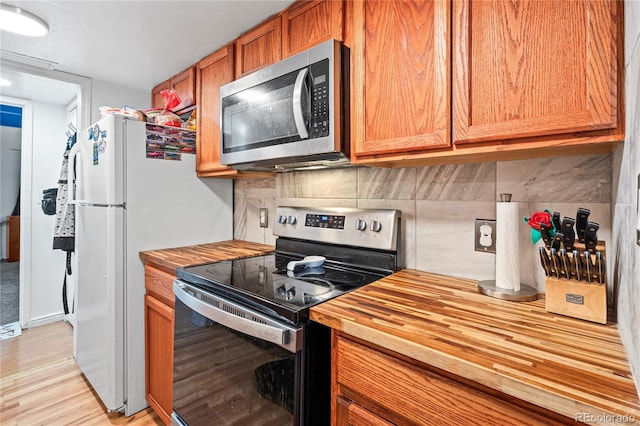 9700 E Iliff Ave Unit E51, Denver, CO 80231 - kitchen with stainless steel appliances, butcher block counters, light wood-type flooring, and tasteful backsplash
