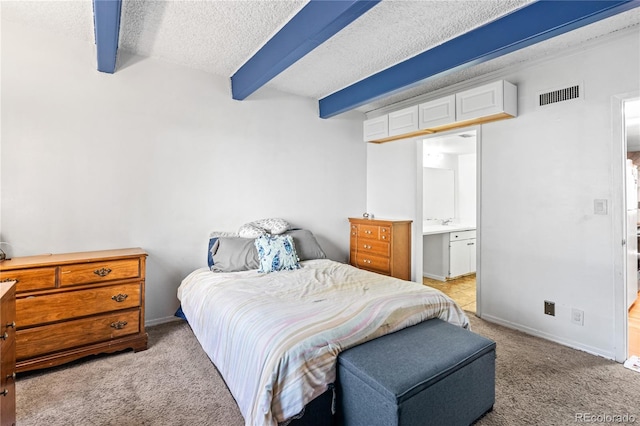 9700 E Iliff Ave Unit E51, Denver, CO 80231 - bedroom with carpet floors, a textured ceiling, beamed ceiling, and connected bathroom