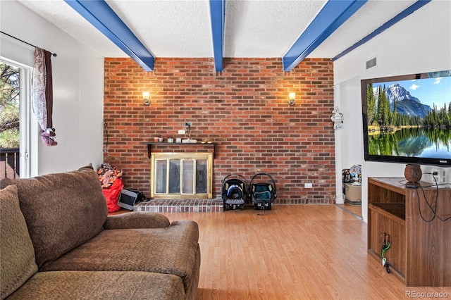 9700 E Iliff Ave Unit E51, Denver, CO 80231 - living room with beam ceiling, wood finished floors, a textured ceiling, and a fireplace