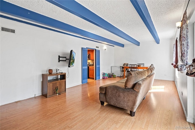 9700 E Iliff Ave Unit E51, Denver, CO 80231 - living area with a textured ceiling, light wood-style flooring, and beam ceiling
