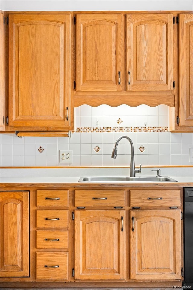 kitchen with tasteful backsplash, dishwasher, and sink