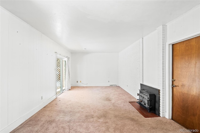 unfurnished living room with carpet and a wood stove